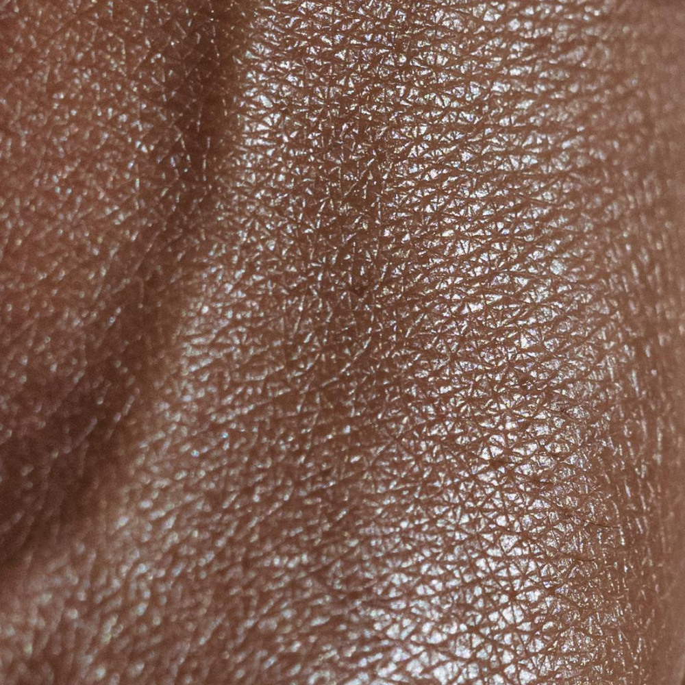This image is a close-up shot of brown skin, highlighting its texture and natural sheen.